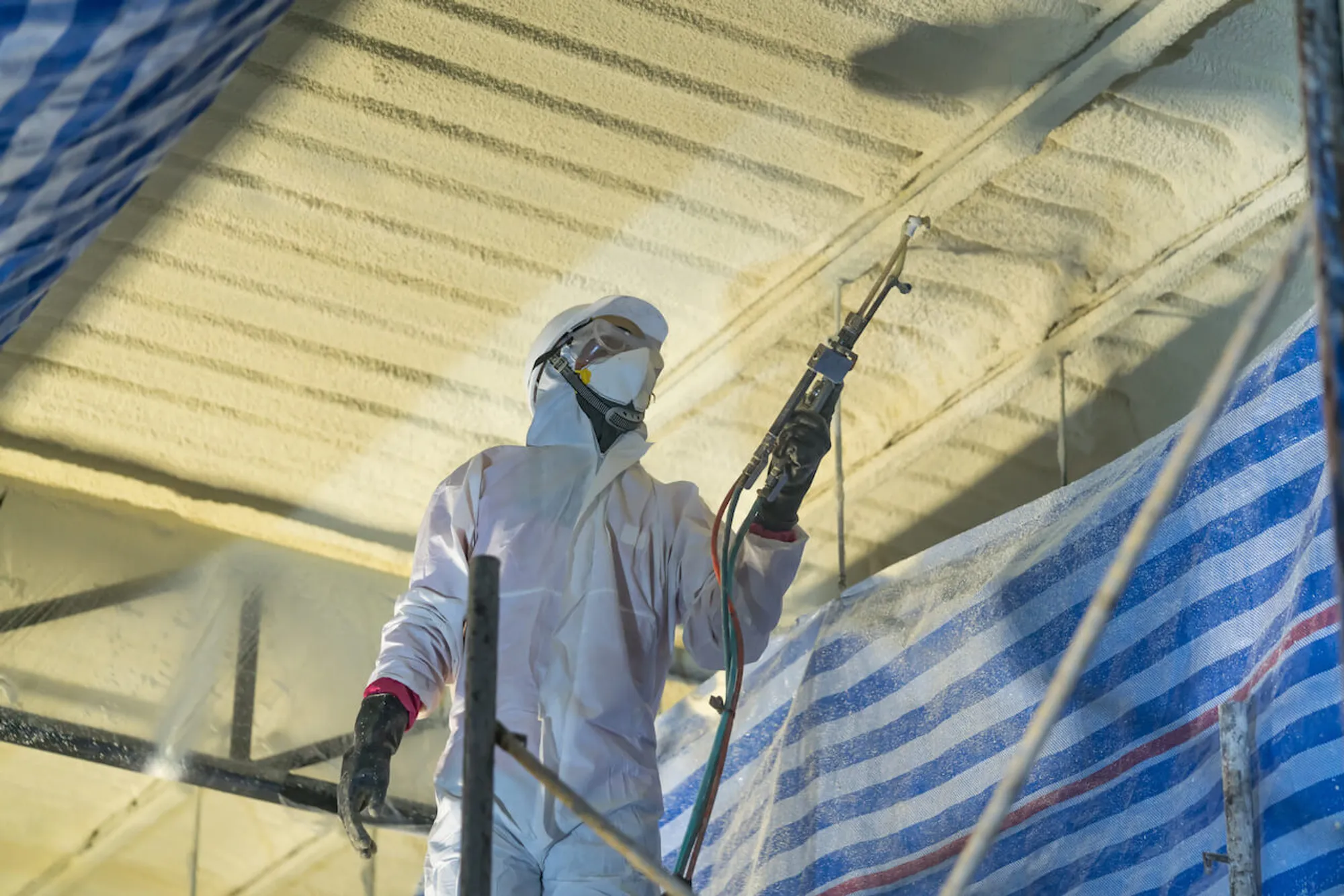 Bosela technician spraying closed-cell urethane foam on an Alaska wall